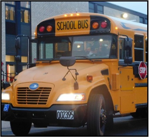 A yellow school bus in front of a two-story building.